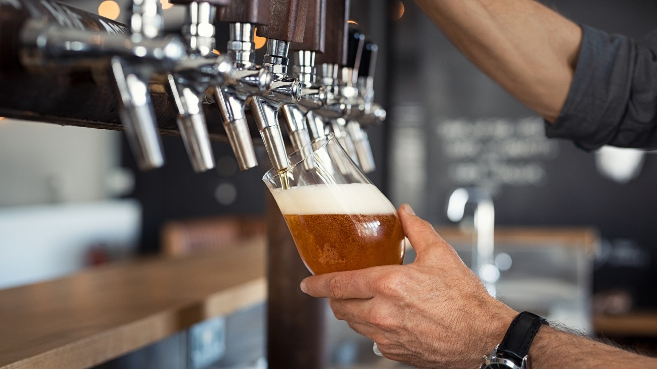 Man tapt bier. Een van de drankjes die lijden onder klimaatverandering