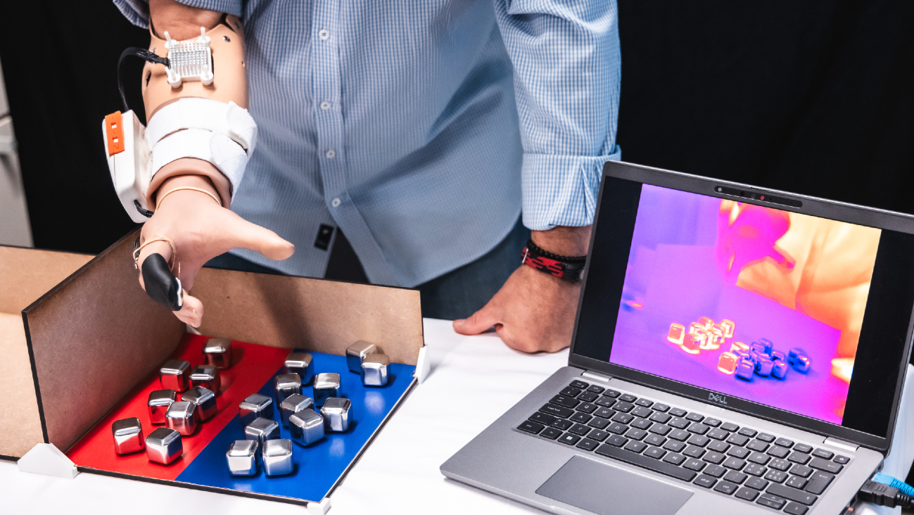 Man met prothese en de MiniTouch sorteert metalen blokjes op basis van temperatuur